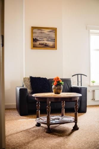 a living room with a couch and a coffee table at Hotel de Reiziger in Ottersum