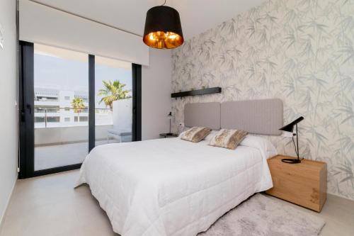 オリウエラにあるEspanatour FLAMENCA VILLAGE 6のベッドルーム(白いベッド1台、大きな窓付)