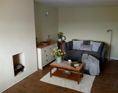 a living room with a couch and a coffee table at Hyfrydle Heights in Pen-y-groes