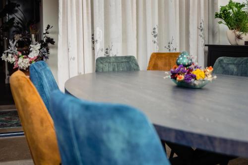 a dining room table with a bowl of flowers on it at Hotel de Reiziger in Ottersum