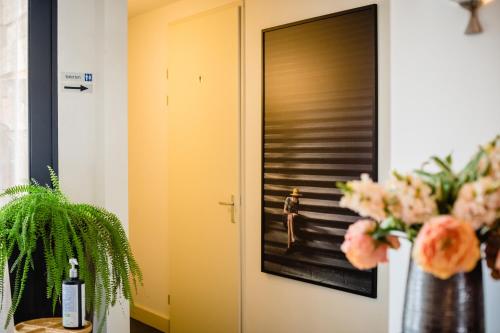 a hallway with a door and a vase of flowers at Hotel de Reiziger in Ottersum
