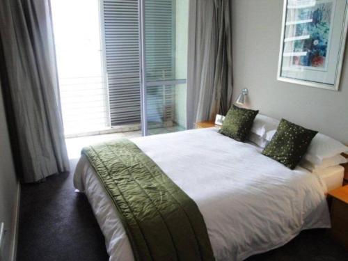 a bedroom with a large white bed with a window at 312 HARBOUR BRIDGE in Cape Town