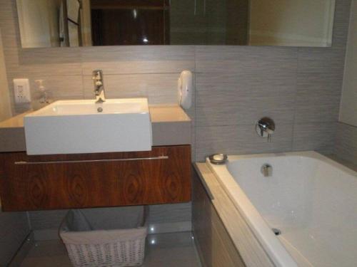 a bathroom with a sink and a bath tub at 312 HARBOUR BRIDGE in Cape Town