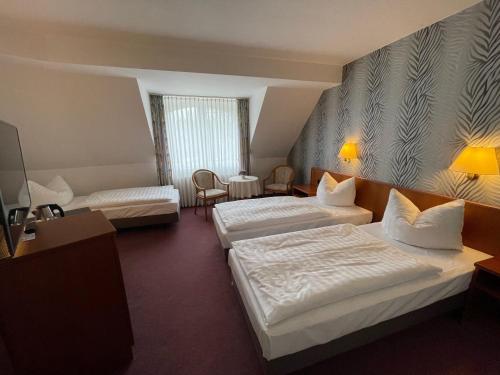 a hotel room with two beds and a table at Hotel Pesterwitzer Siegel in Dresden