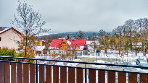 a snow covered yard with houses and a fence at Apartamenty VIP Centrum - Wczasowa 17 by Royal Aparts in Świeradów-Zdrój