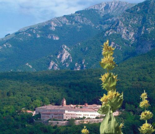 a building in the foreground with mountains in the background at Casetta romantica a Collepardo in Collepardo