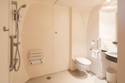 a white bathroom with a shower and a toilet at Premiere Classe Le Havre Centre-LES DOCKS in Le Havre