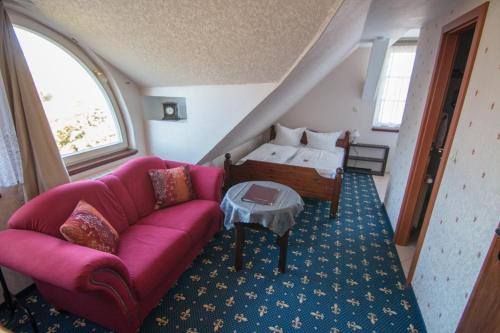 ein Wohnzimmer mit einem rosa Sofa und einem Bett in der Unterkunft Schloss Zehdenick in Zehdenick