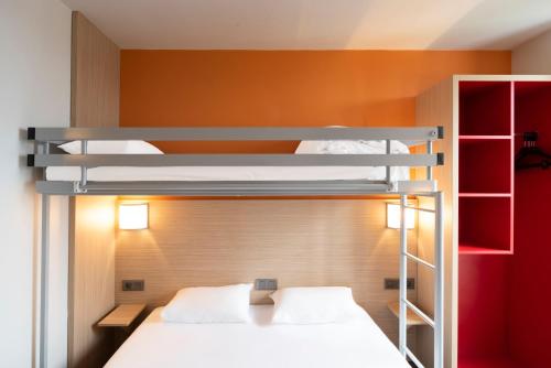 two bunk beds in a room with a red wall at Premiere Classe Le Havre Centre-LES DOCKS in Le Havre