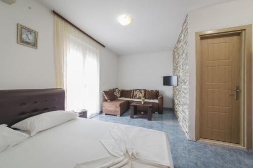1 dormitorio con cama, puerta y sofá en Apartments Boki, en Ulcinj