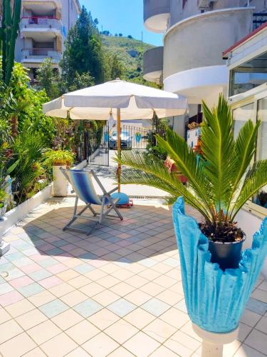 a patio with a chair and an umbrella and a plant at Le Twins -Bed and Breakfast in Tropea
