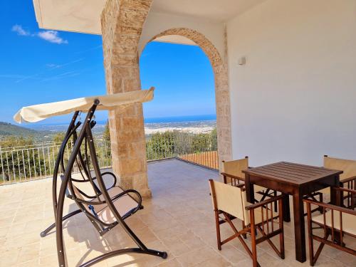 a patio with a table and chairs and a view of the ocean at Villa Anna holiday house in Selva di Fasano