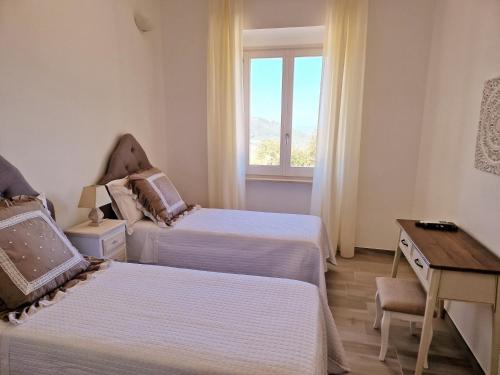 a room with two beds and a desk and a window at Villa Anna holiday house in Selva di Fasano