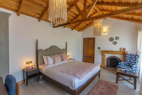 a bedroom with a large bed and a fireplace at Seclude Ramgarh Willows in Rāmgarh