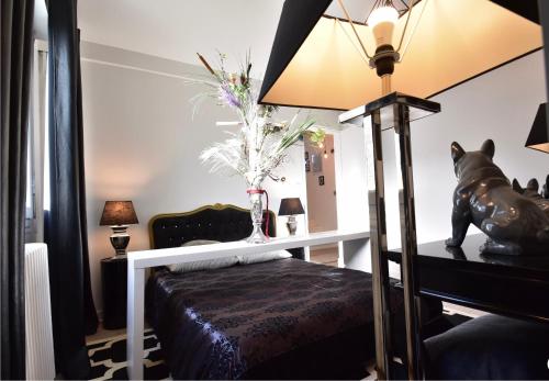 a bedroom with a bed and a vase of flowers at Endroit Cosy in Angers