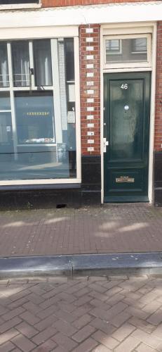 ein Gebäude mit zwei Fenstern und einer schwarzen Tür in der Unterkunft Room Aris, not for parties, not a hotel in Amsterdam