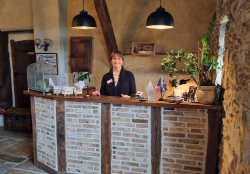 a woman standing behind a brick counter in a room at Domaine de Bassilour in Bidart
