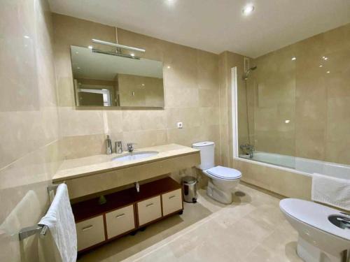 uma casa de banho com um lavatório, um WC e um espelho. em Chicflat Avenida España Ideal para familias em Estepona