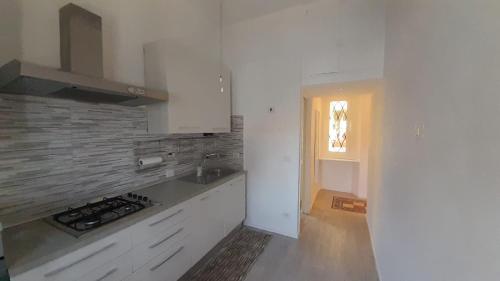 a kitchen with white cabinets and a sink and a window at Dimora Novella in Lido di Ostia