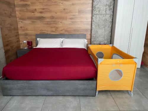 a bedroom with a bed with a red blanket at HappyHome Appartamento 4 posti letto Rivarolo Canavese in Rivarolo Canavese