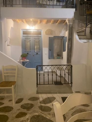 a stairway with a blue door and a chair at BIANCO BLUE in Tinos