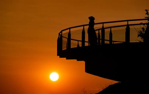 eine Person, die bei Sonnenuntergang auf einer Treppe steht in der Unterkunft Medora Auri Family Beach Resort in Podgora