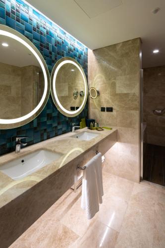 a bathroom with a tub and a sink and a mirror at Dedeman Kartepe Kocaeli in Kocaeli