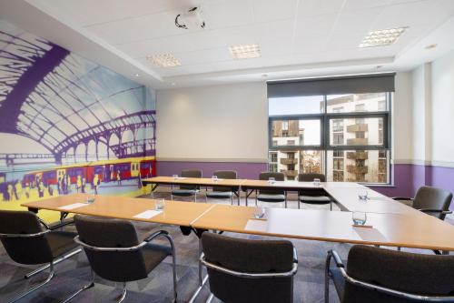 a conference room with tables and chairs and a large window at Leonardo Hotel Brighton in Brighton & Hove