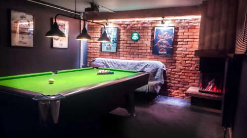 een kamer met een pooltafel en een bakstenen muur bij Willa Ramzówka - Domek w Beskidzie Sądeckim in Nowy Sącz