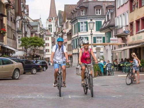 2 personnes en vélo dans une rue de la ville dans l'établissement Hotel Untertor - 24H Self Check-in, à Altstätten