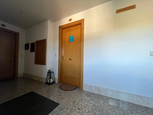 a hallway with a wooden door and a wall at A. Rural LA COVATILLA en Navacarros in Navacarros