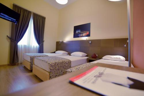 a hotel room with two beds and a table at Orestias Kastorias in Thessaloniki