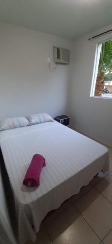 um quarto com uma cama branca e uma toalha roxa em Apartamento inteiro 2 quartos mobiliado em Jaraguá do Sul