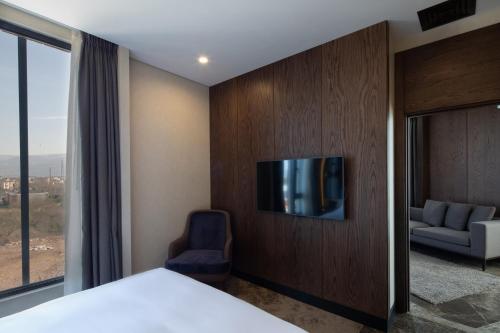 a hotel room with a tv on a wall at Dedeman Kartepe Kocaeli in Kocaeli