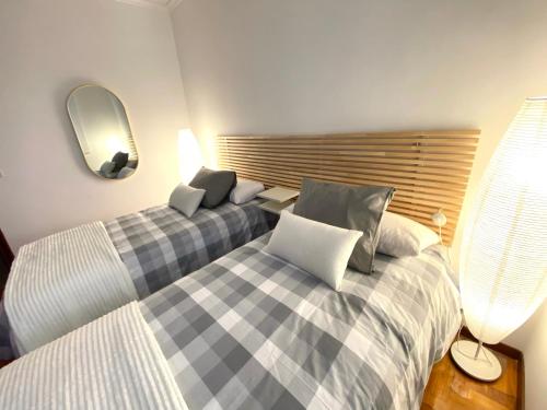 a bedroom with two beds and a mirror at Casa Palmiras in Marín