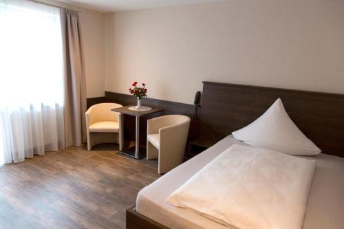a hotel room with a bed and a table and chairs at Hotel Lorenz in Bad Füssing