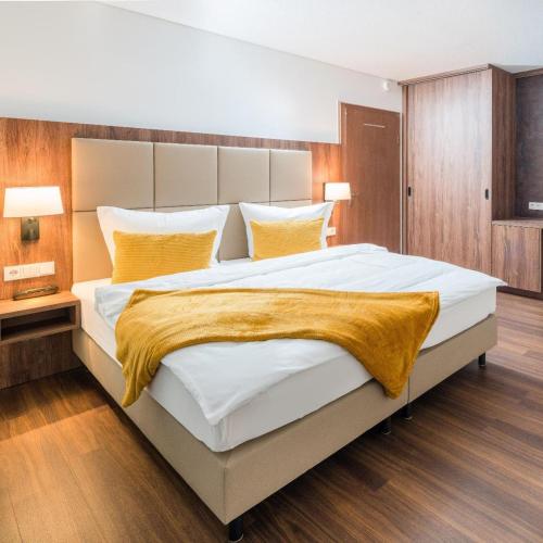 a bedroom with a large white bed with yellow blankets at Hotel Lorenz in Bad Füssing