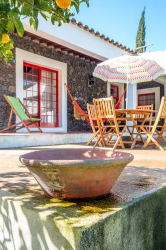 a bowl sitting on a table with chairs and an umbrella at Quinta dos Reis in Biscoitos