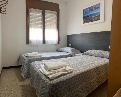 Dos camas en una habitación de hotel con toallas. en Mas Tauler, en Sant Antoni de Calonge