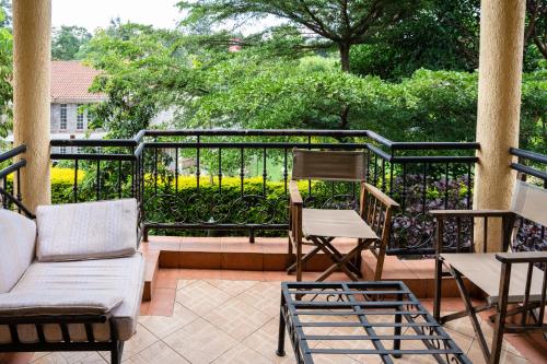 a porch with a couch and chairs and a fence at dreamplace Gigiri in Nairobi