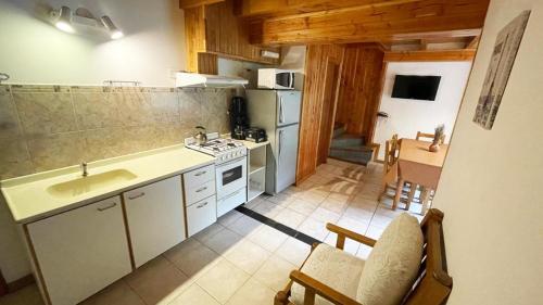 a kitchen with a sink and a stove top oven at Apart Hotel del Pellin in San Martín de los Andes