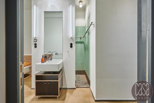 ein Bad mit einem Waschbecken und einer Dusche in der Unterkunft casanando prestige Suites - HiFi Erlebnis in Zoo - und Citylage in Leipzig
