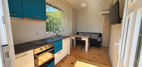a kitchen with blue cabinets and a table and a window at Къща за гости Свети Йоан Кръстител in Varna City