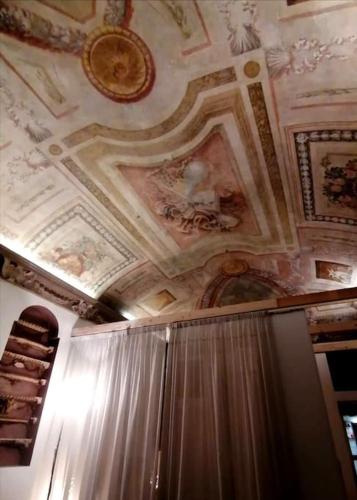 a room with a ceiling with paintings on it at Residenza alla Scala del Borgo in Bologna