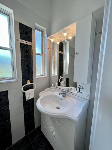 a white bathroom with a sink and a mirror at Alepochori Seaside Village in Kato Alepochori