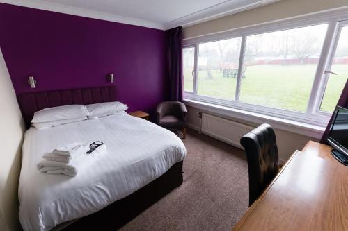 a bedroom with a bed with towels on it at Sporting Lodge Inn Middlesbrough in Middlesbrough