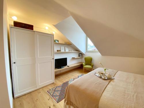 a attic bedroom with a bed and a tv at Casa Ginepro via Mazzini in Turin