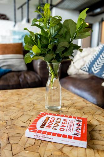 a vase with a plant and a book on a table at Belvidere Country Estate in Karkloof Nature Reserve
