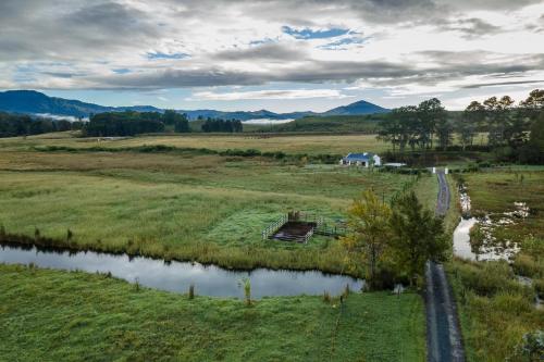 an aerial view of a field with a river at Belvidere Country Estate in Karkloof Nature Reserve