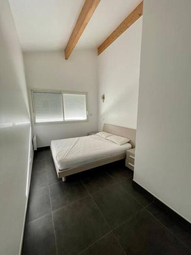 une petite pièce avec un lit et une fenêtre dans l'établissement APPART-SPACIEUX-VUE MER-4 PERS, à Propriano